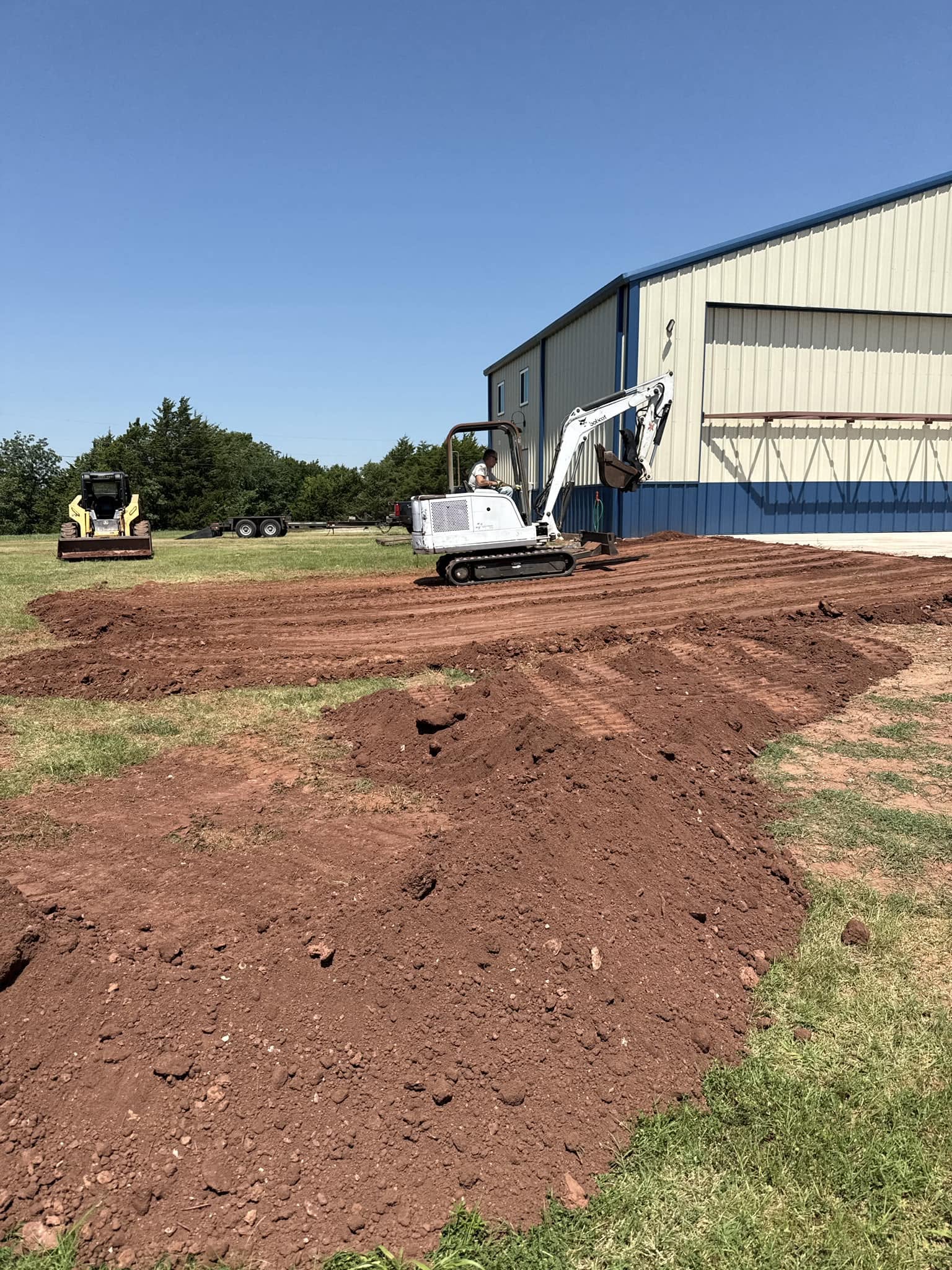 Mini excavator grading a fresh building pad